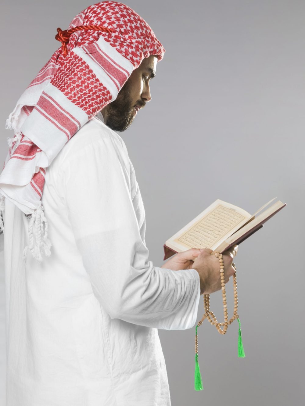muslim-man-reading-from-quran-holding-praying-beads